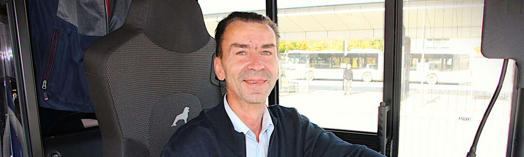 Ein Mann sitzt hinterm Lenkrad eines Busses