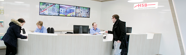 Zwei MEnschen stehen an einer weißen Beratungstheke