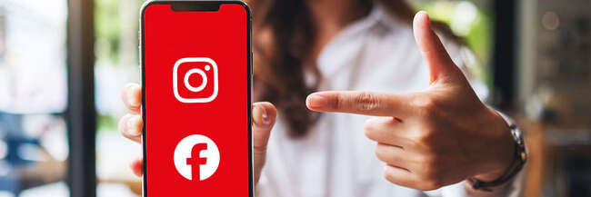 Frau zeigt auf ein Smartphone mit rotem Bildschirm, auf dem die Symbole von Instagram und Facebook zu sehen sind.