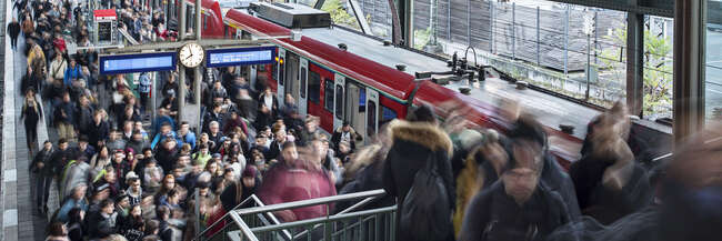 Viele Menschen kommen aus einer S-Bahn und überfüllen den Bahnsteig sowie die Bahnsteigtreppe.