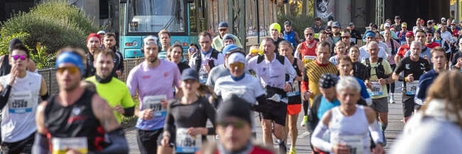 Marathonläufer im Vordergrund, hinten eine Straßenbahn